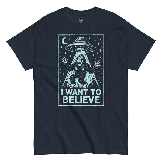 Cryptid UFO T-shirt in navy featuring Bigfoot under flying saucer with I Want To Believe text, retro alien parody design, By StrangeAndTwisted.Com