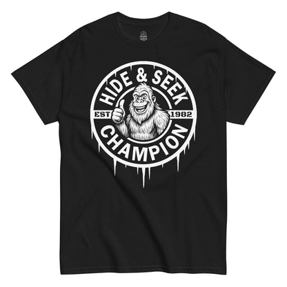 Bigfoot Hide And Seek Champion thumbs-up T-shirt on black, funny cryptid graphic design