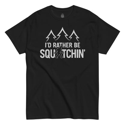 I’d Rather Be Squatchin Bigfoot T-shirt on black, cryptid graphic with sasquatch and pine trees