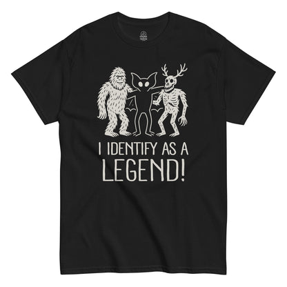 Black cryptid T-shirt featuring Bigfoot, Mothman, and Wendigo with “I Identify As A Legend” slogan, funny paranormal apparel by Strange and Twisted
