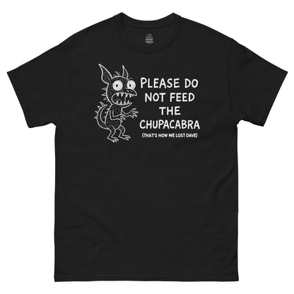Funny Chupacabra T-shirt featuring white cartoon cryptid art and “Please Do Not Feed the Chupacabra” text on black fabric.