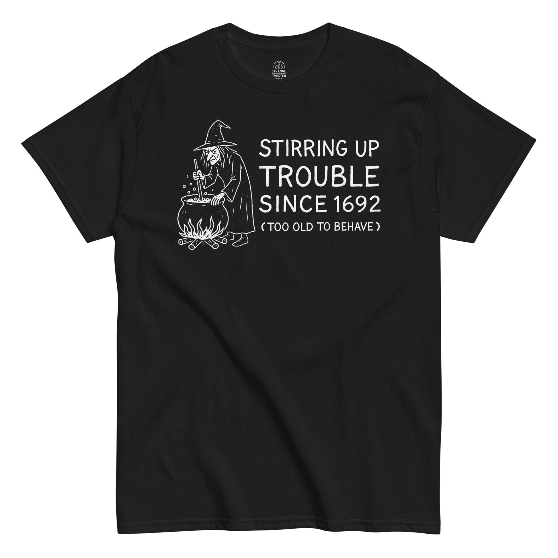Funny witchcraft T-shirt with white artwork of a witch stirring a cauldron and text “Stirring Up Trouble Since 1692” on black fabric.