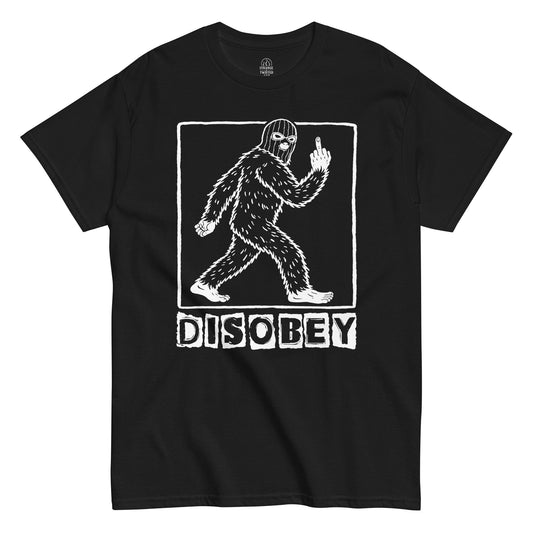 Disobey Bigfoot cryptid T shirt on black featuring walking Sasquatch silhouette with rebellious gesture