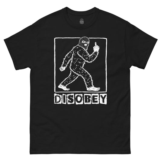 Disobey Bigfoot cryptid T shirt on black featuring walking Sasquatch silhouette with rebellious gesture