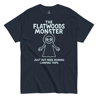 Navy Flatwoods Monster T-shirt with white cryptid illustration and text “Just Out Here Ruining Camping Trips,” paranormal humor apparel