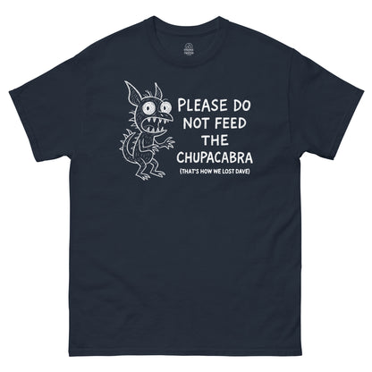 Funny Chupacabra T-shirt with white monster artwork and humorous quote on navy fabric.